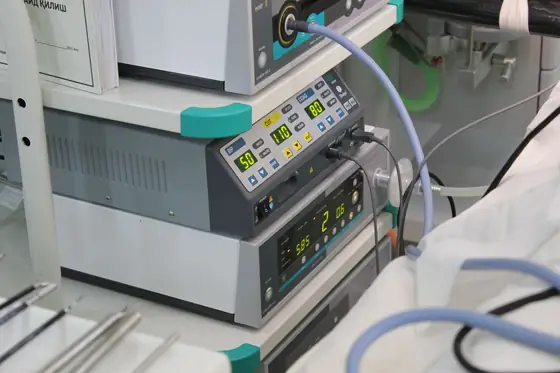 A stack of clinical monitoring units with illuminated numeric displays and cabling