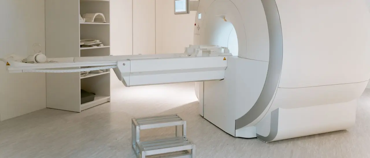 An open magnetic resonance scanner and its patient table in a quiet imaging room