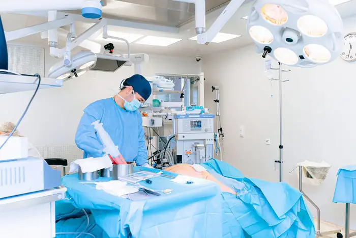 A surgeon working at the operating table in a well-equipped operating room