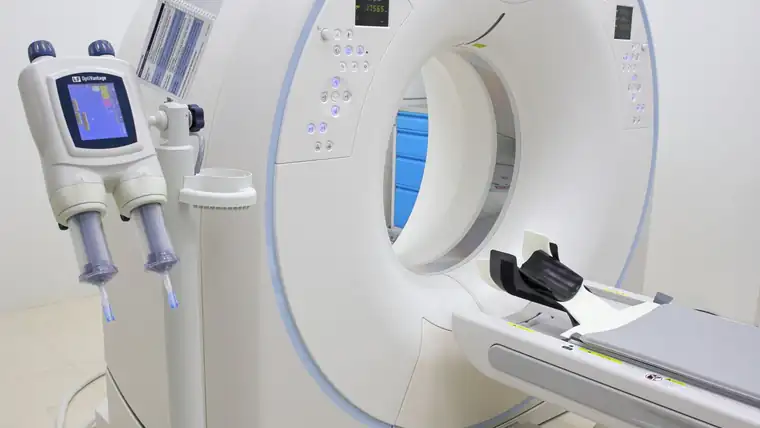 A computed tomography scanner and its patient table in a diagnostic imaging room